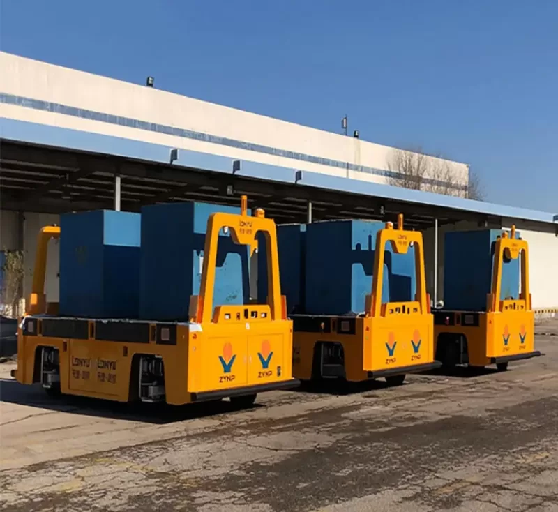 Outdoor Automated Guided Vehicles (AGVs) performing efficiently in a complex industrial outdoor environment, featuring heavy-duty all-terrain mobility with blue and yellow vehicle bodies.