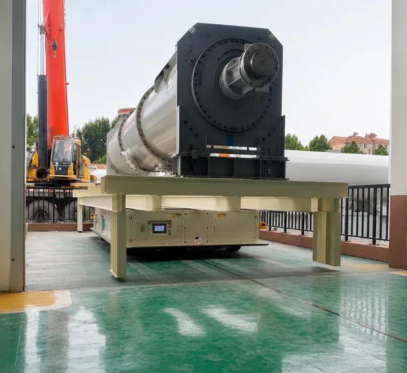 80-ton heavy-duty automated guided vehicle transporting a large transformer component inside a modern industrial manufacturing facility for crane-free material handling banner